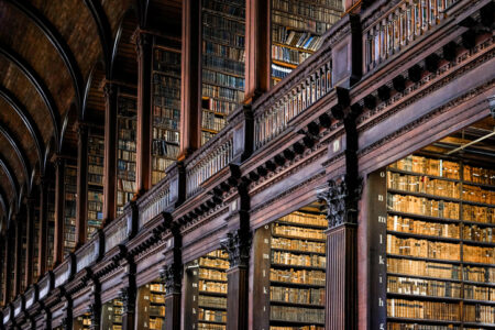 Low Angle View Of Books On Shelves In Long Room Of Trinity College Old Library In Dublin.