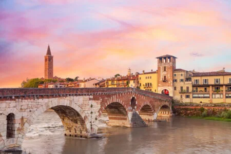 Famous Verona Landmark. Ponte Di Pietra Bridge Over Adige River During Colorful Sunrise.
